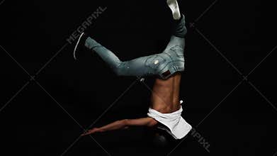 Athlete male break dancer with put on bike helmet actively spins on his head