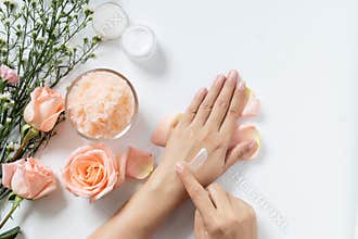 Natural skincare concept. woman apply white cream on her hands on white background with jar of cosmetic cream, salt spa scrub