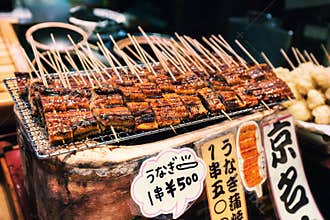 Grilled unagi or fresh water eel on sticks as street food at Nishiki market, Kyoto, Japan