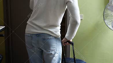 Handsome young man opening door to enter home