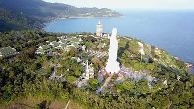Upper view white buddha statue lit by sun rays in summer