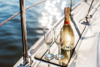 Empty glasses and bottle with champagne with sea background