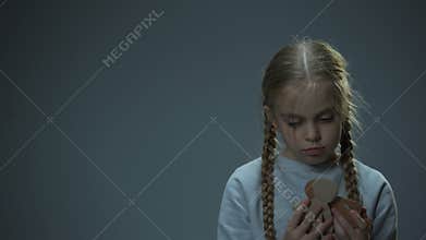 Disappointed little child holding paper family, orphan missing parents, concept