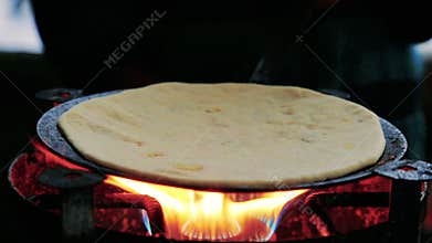 Cooking roti on the stove top.
