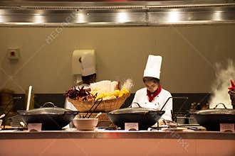 Chef and assistant Chefs cooking and prepared buffet food at restaurant in night time in Bangkok, Thailand