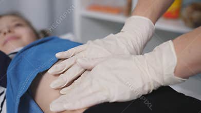 The doctor palpated the abdomen of a young patient in a medical office., close-up.