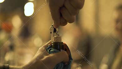 Male hands opening wine bottle with corkscrew on holiday table close up. Man using cork for uncork wine bottle