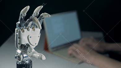 Fingers of a robotic arm are doing an okay gesture