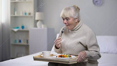 Smiling old woman eating dinner in nursing home, social security for aged people