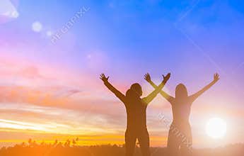 Two happy successful women raising arms toward beautiful scenery. People achieve life target goal. Business women raises hands as