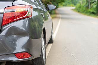 Back of gray car get damaged from accident on the road. Vehicle bumper dent broken by car crash. Road accidents and car insurance