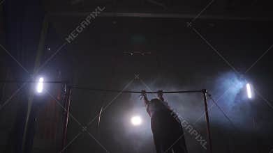 Gymnast exercises on high horizontal bar HD slow-motion video. Athlete training gymnastics skills and performing giant