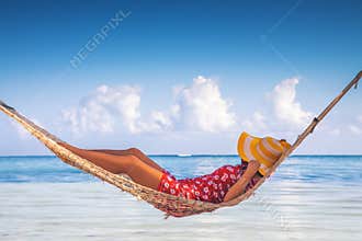 Girl relaxing in a hammock on tropical island beach. Summer vacation in Punta Cana, Dominican Republic