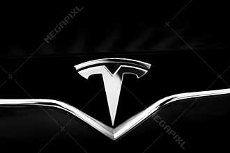 Tesla Emblem on Black Car. Close-Up Silver Logo