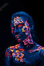 Beautiful flowers in UV light on a young girl face and body