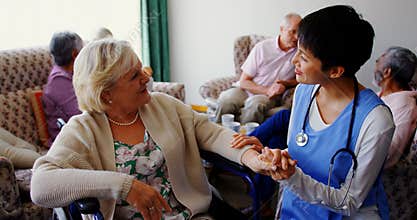 Front view of Asian female doctor interacting with senior woman at nursing home 4k