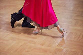 Graceful dance couple tangoing at the ballroom.