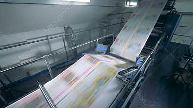Printing office and coloured paper rolling through a machine