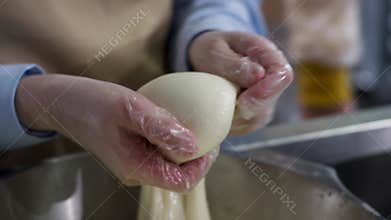 Close up for hands in cooking gloves preparing mozzarella cheese, food concept. Frame. Worker from cheese factory