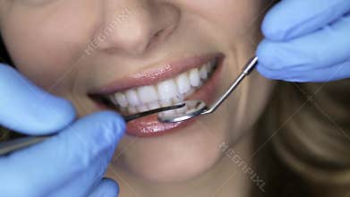 Pretty woman`s teeth examining in dental clinic