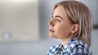 Close-up face of positive relaxed domestic woman drinking coffee enjoying weekend at home