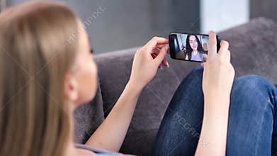 Two happy young woman enjoying video webcam chatting together using smartphone close-up