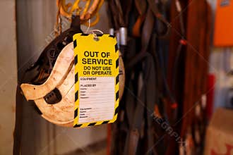 Out of service tag attached on faulty defect safety fall protection abseiling helmet