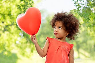 African american girl with heart shaped balloon