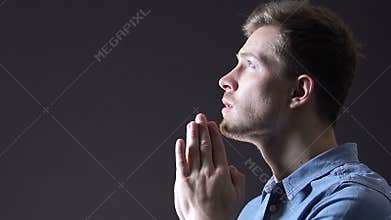 Light falling on man praying faithfully to god, belief in changes for better