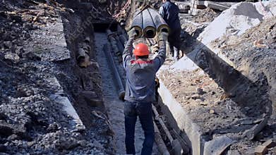 Workers with construction crane put new water pipes with concrete slabs