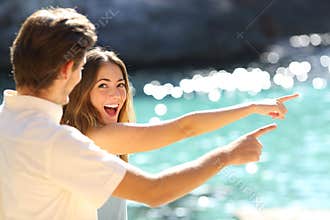 Excited teens pointing beach on vacation