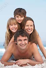 Young Family Having Fun On Beach Holiday