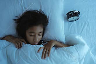 Asian girl  sleeping on the bed at midnight. Inside the bedroom is dark  little girl deep sleep