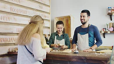 A woman buys cheese in a small family store. Small business concept