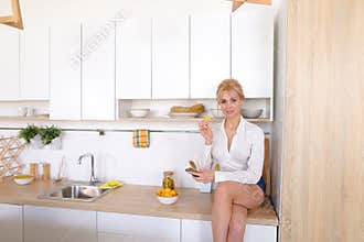 Pretty girl uses smartphone on Internet and eats potato chips si