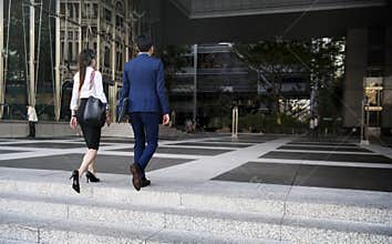 Business couple walking cross a street