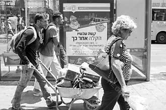 The inscription on advertising `now hard afterwards it will be easier`. Men are carrying a heavy cart.