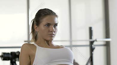 Sports woman pulling weight on fitnes equipment in sports club interior