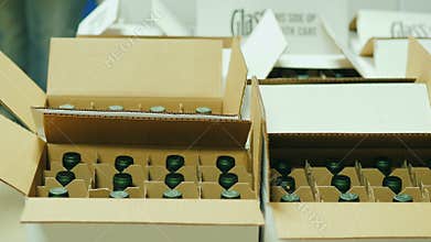 Packing of finished products in the winery. Bottles with white wine are put in cardboard boxes