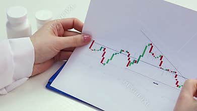 Scientist examining graph curves, conducting medical research, comparing data