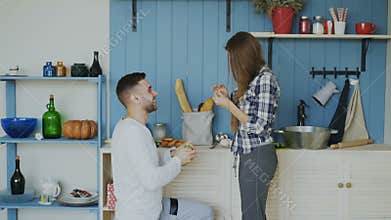 Young man making proposal to his girlfriend in the kitchen at home
