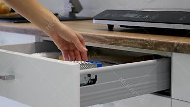 Woman Hand Opening Drawers Of A White Kitchen Cupboard