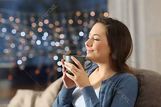 Woman relaxing drinking coffee in the night at home