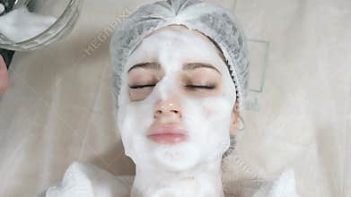 Young pretty woman receiving treatments in beauty salons. Young beautiful dark-haired woman in the office beautician