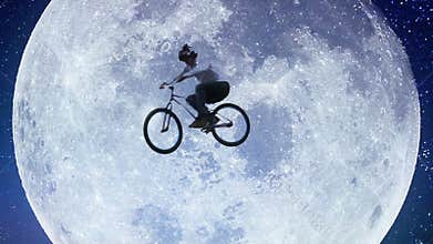 Bicycle moon flyer, male bike across night sky slow motion