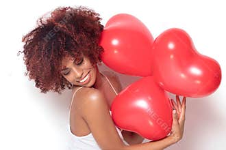African american girl with heart shaped baloons.