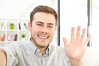 Man waving on a video call at home