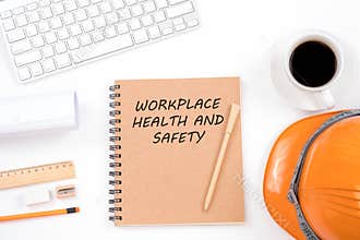 Workplace health and safety concept. Top viwe of modern workplace with safety helmet, office supplies, a cup of coffee and