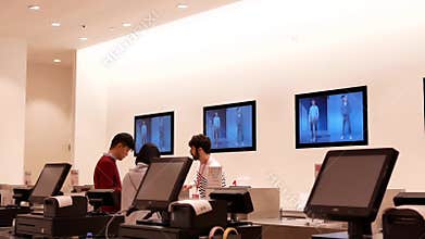 Motion of shopper paying clothes at check out counter inside uniqlo store