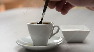 Pouring sugar in coffee cup